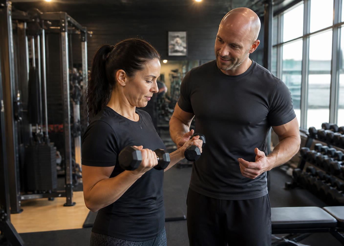 Luke coaching a client through a dumbbell exercise in his Worcester gym